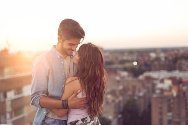 a tall man is hugging his girlfriend on a date