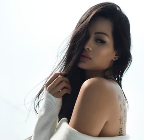 a dark portrait of a beautiful asian woman wearing a white sweater