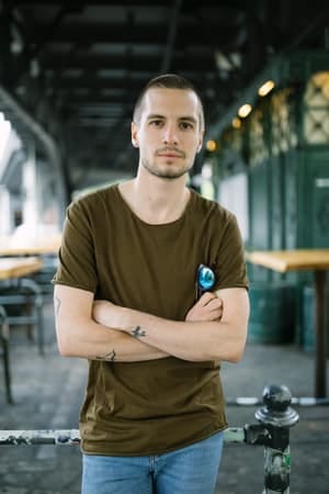 a young serious man posing with his arms crossed