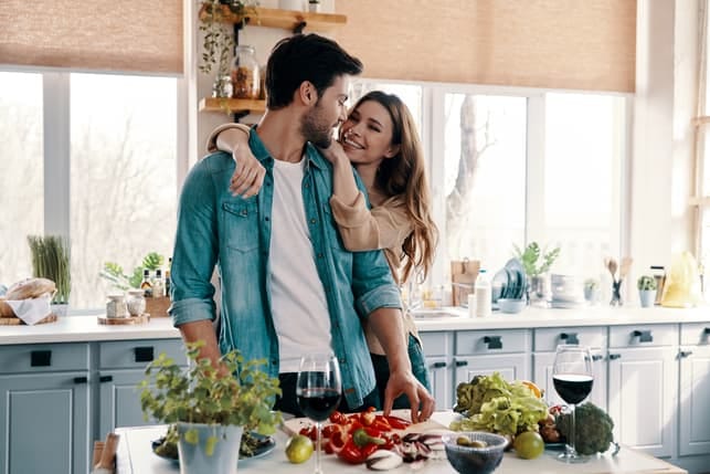 a couple hugging and spending time in the kitchen together