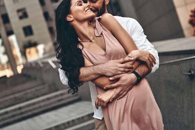 a beautiful couple hugging and posing together