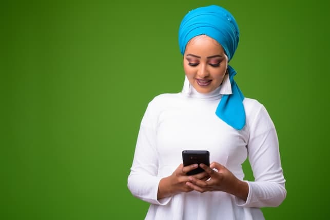 a young woman wearing traditional clothing and checking her smartphone