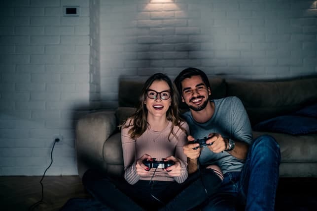 a couple playing video games in the evening
