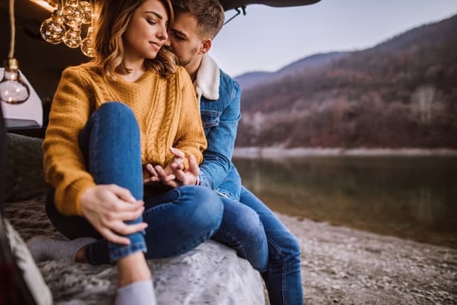 a couple is hugging while hiking and enjoying the nature