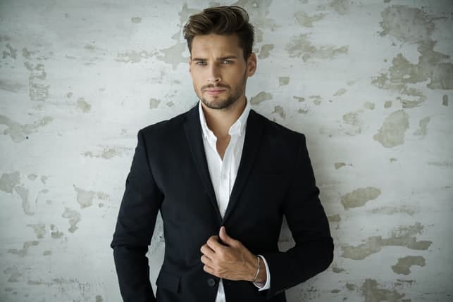 a well-dressed handsome man is posing