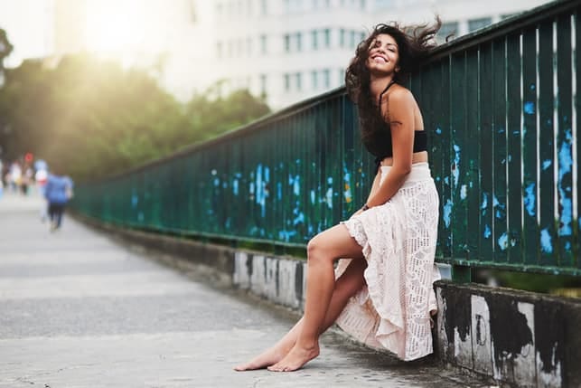 an attractive woman is posing on a bridge