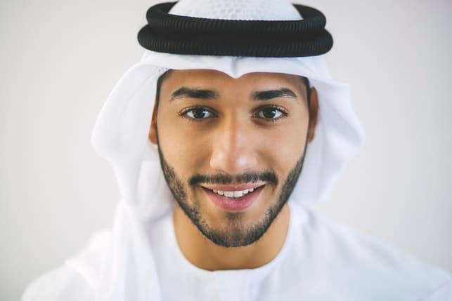 a portrait of a young muslim man smiling