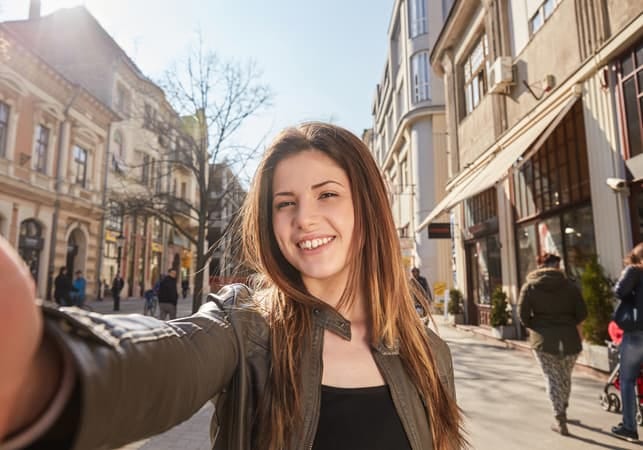 a young woman is taking a selfie while walking through the city