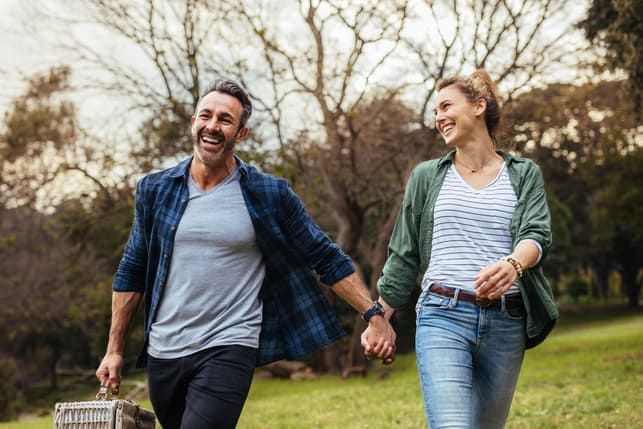 a happy middle-aged couple having fun and walking outdoors