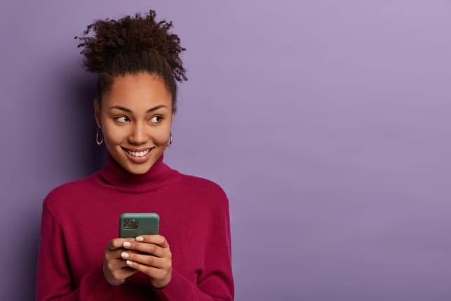 an attractive young woman is using her smartphone and enjoying online dating