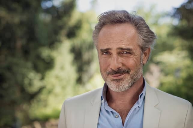 a man over 50 smiling cunningly