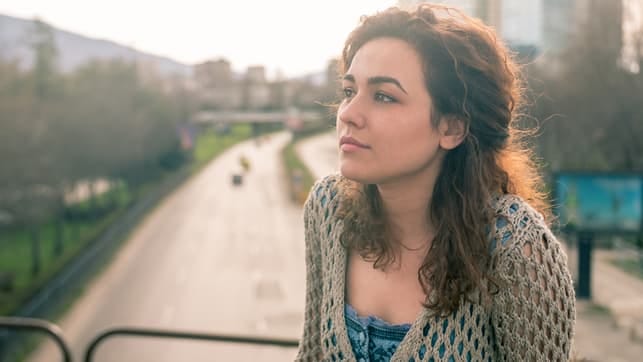 a portrait of a curly dark-haired woman in the city