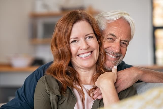 a mature couple hugging and posing together