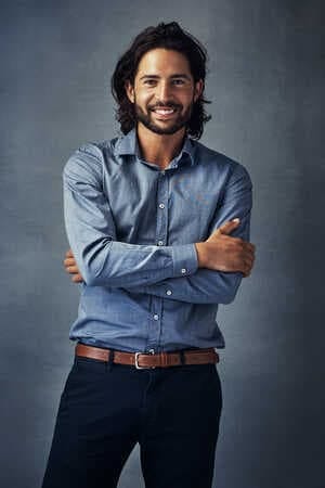 an attractive man in a shirt posing on a grey background