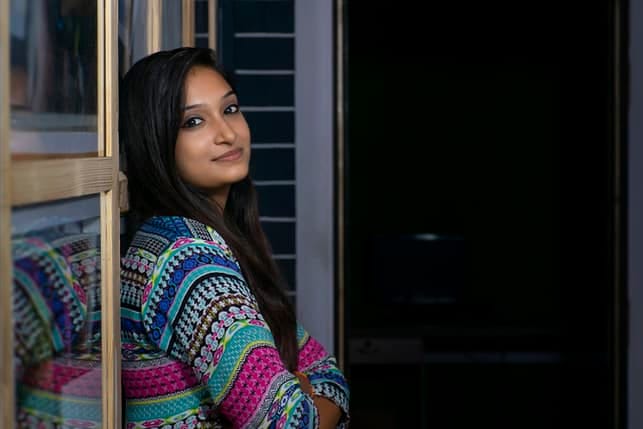 a young Indian woman in a sweater posing indoors