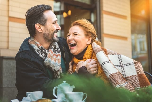 a mature couple hugging and laughing together while spending time at home