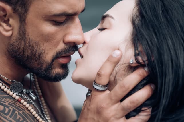 a man kissing his girlfriend passionately