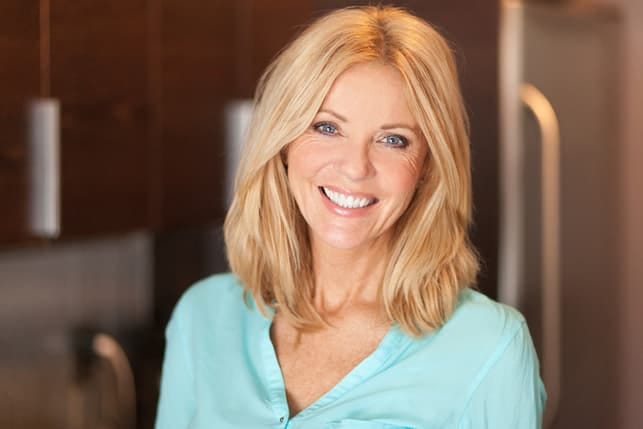 a mature blonde woman posing indoors