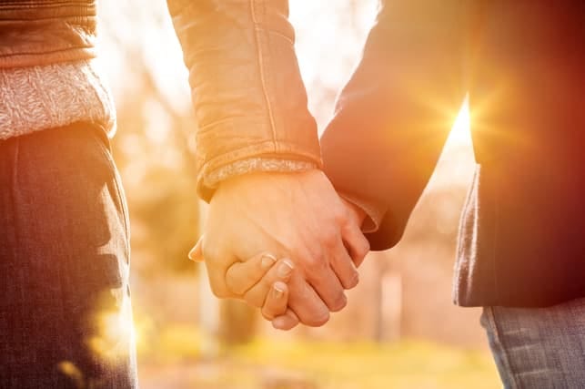 a couple holding hands while walking together