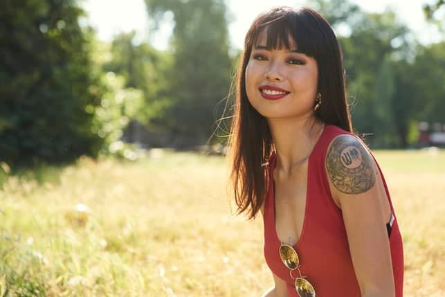 an attractive asian woman with a fringe and a tattoo
