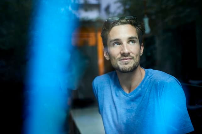 a man wearing a blue shirt is thinking