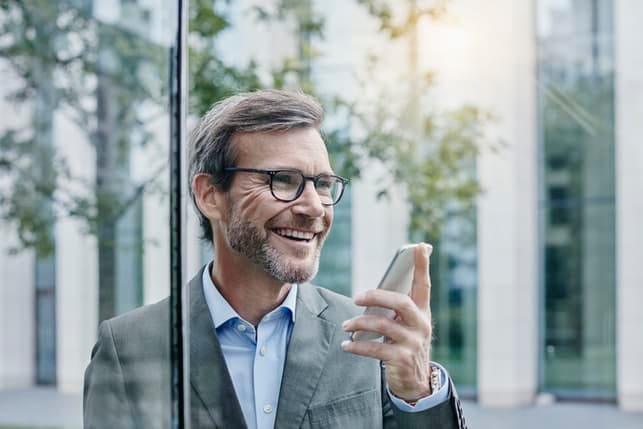 a portrait of a happy man over 40 using his smartphone